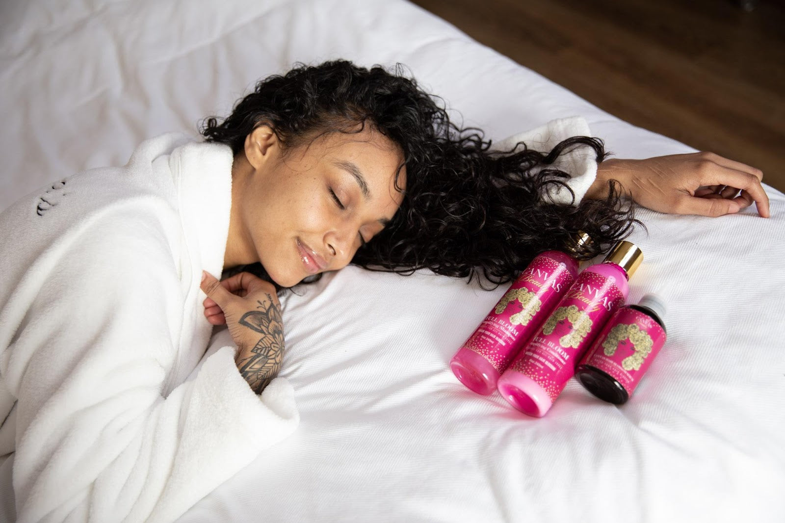 canvas girl with moisturized hair laying down on bed happy with canvas product set